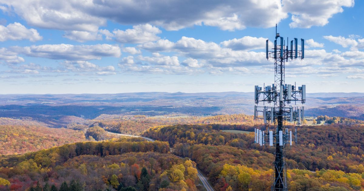 Aerial view of mobiel phone cell tower over forested rural area of West Virginia to illustrate lack of broadband internet service